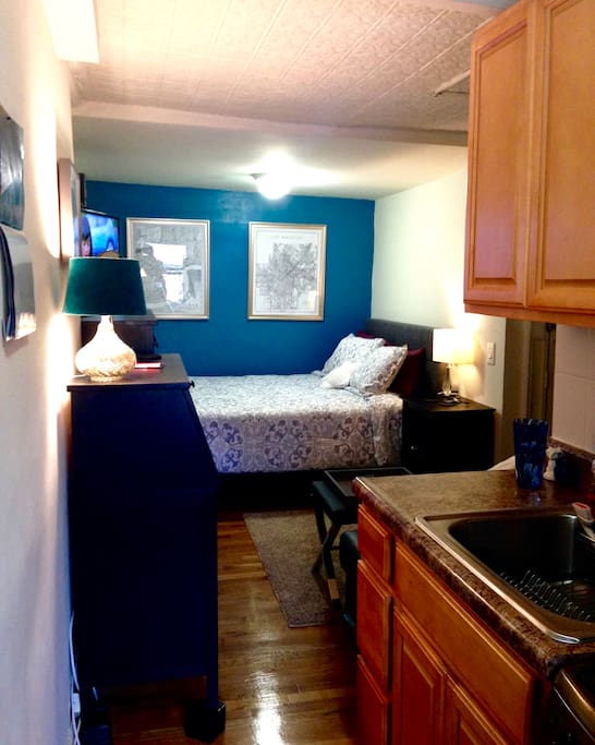 Bedroom is snuggled in the interior of the building for a quiet and calm space away from the city noise. Thick brick walls in this older building mean you never hear the neighbors in adjacent apartments. Bed is flush against the far wall.