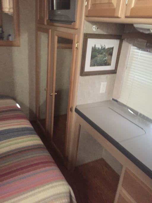 There is storage for folded clothes in the bedroom with a small closet in the hall for hanging clothes