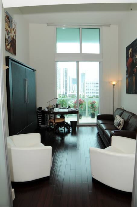 Living room with very hi ceilings and extra bed in wall
