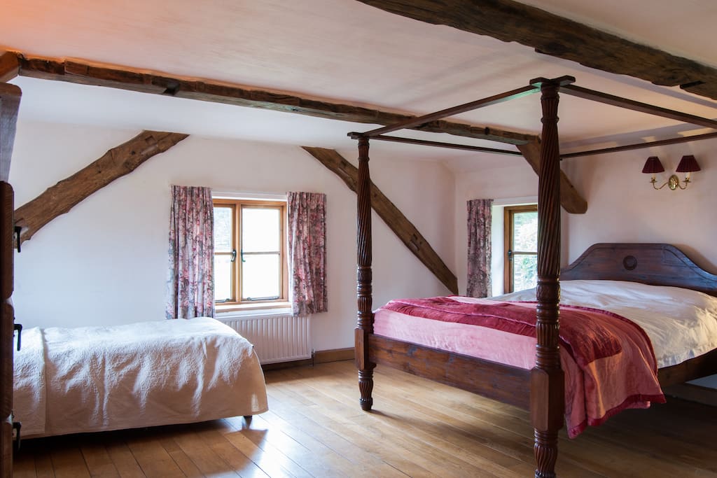 Main bedroom with king size four poster and single wooden bed