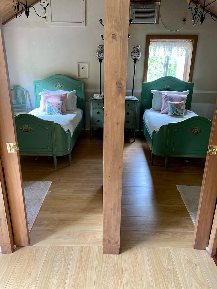 Downstairs mirror image bedrooms, twin bed and shower in each with pocket doors between (may open to create a combined room or close for privacy).