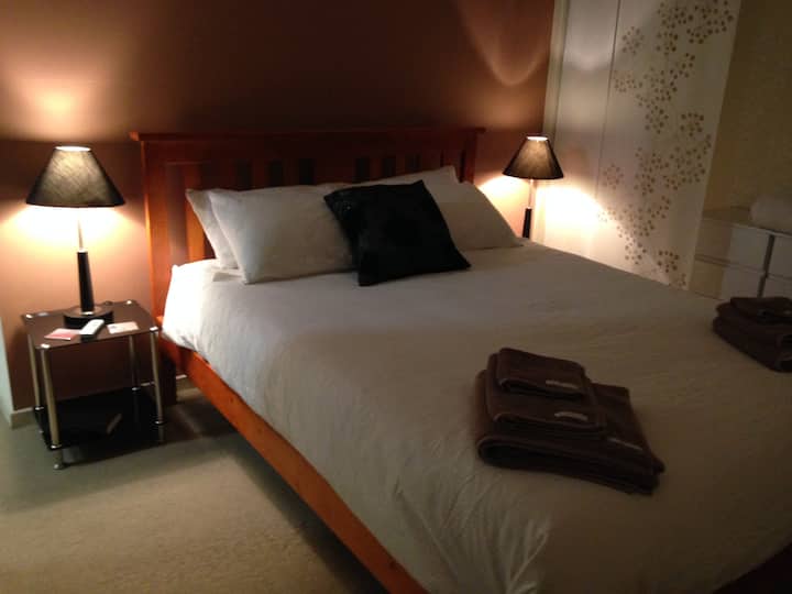 Ampia camera da letto con asciugamani e lenzuola Sheridan di qualità.