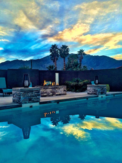 Pool area with beautiful sunsets, double waterfall feature, fire pit, optional heated pool, lounge and pool chairs