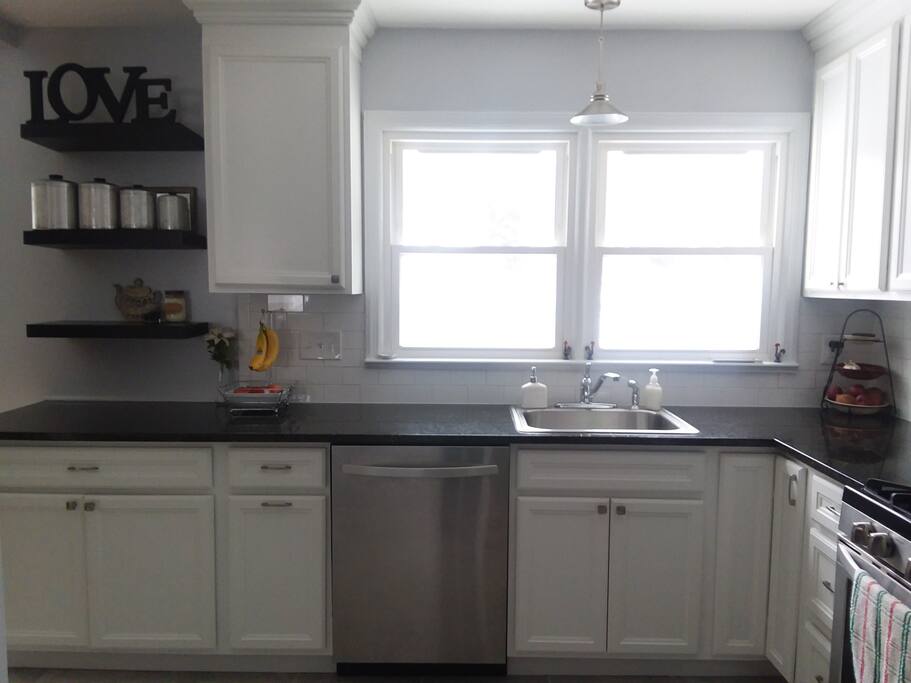 Updated kitchen with white cabinetry, granite countertops, and stainless steel appliances