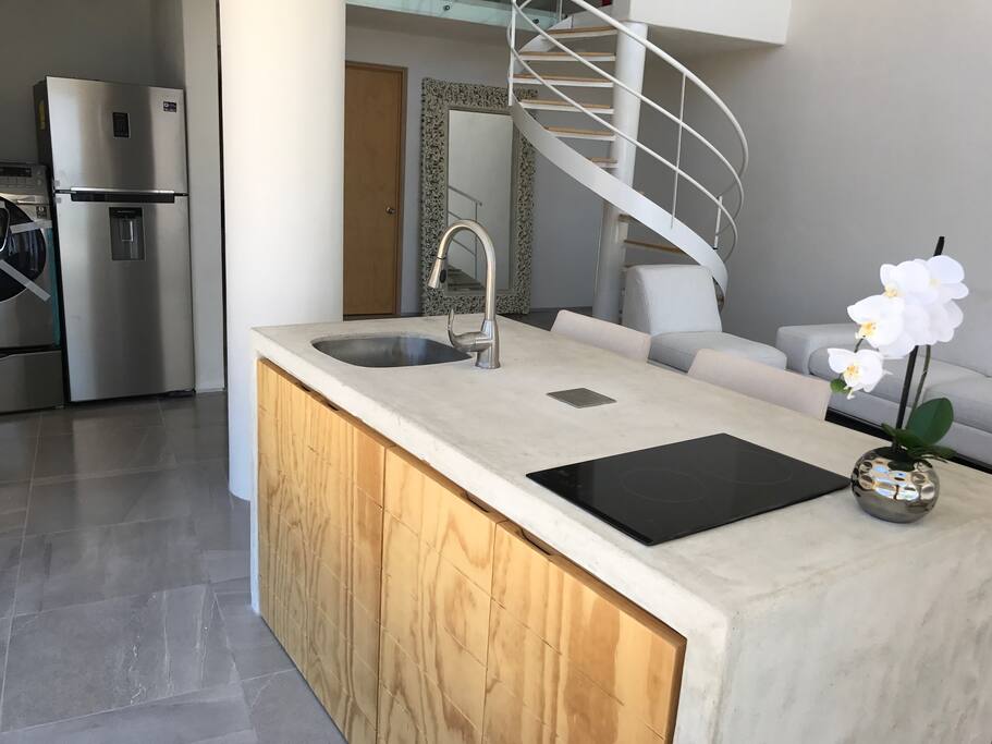 Cocina con parrilla eléctrica, refrigerador y centro de lavado