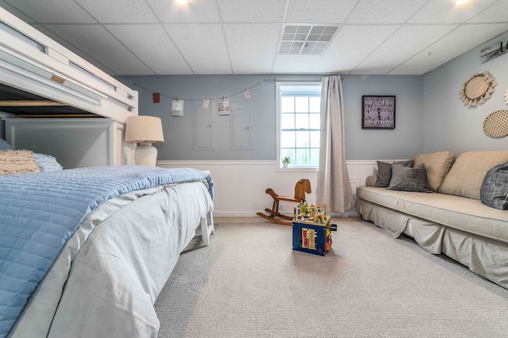 Spacious 4th Bedroom Sleeps 4 – Features Twin Over Full Bunk Bed Combo Located on the ground-level basement, this bright bedroom offers stunning mountain views through a large window. Perfect for families, it includes a cozy couch area and toys for k