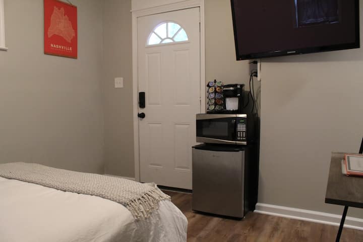 View from the inside the suite of the entry way, bed, TV, and some additional amenities.