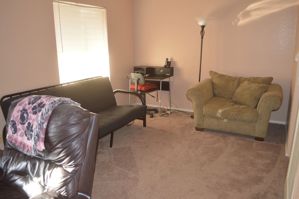 Computer desk, pullout couch and chair in lounge area