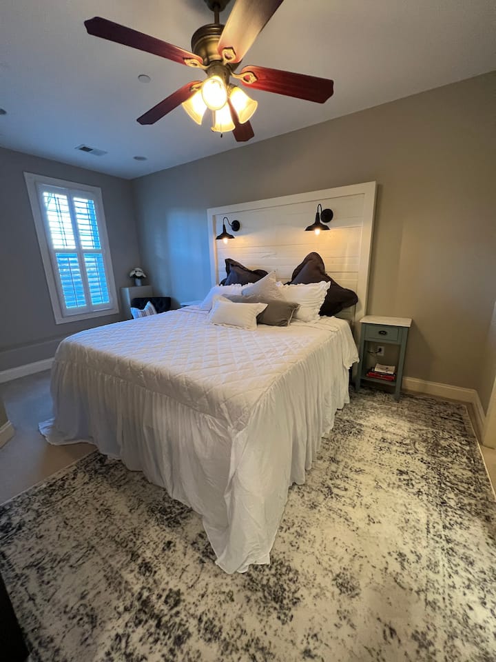 ห้องนอนใหญ่พร้อมฟูกนอนขนาดคิงไซส์ใหม่สะดวกสบายมาก หัวเตียงที่มีไฟส่องสว่างสไตล์ฟาร์มสไตล์โมเดิร์น