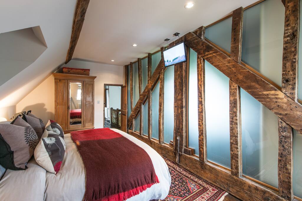Original 17th Century beams against a frosted glass wall is a highlight of this beautiful, light and airy room.
