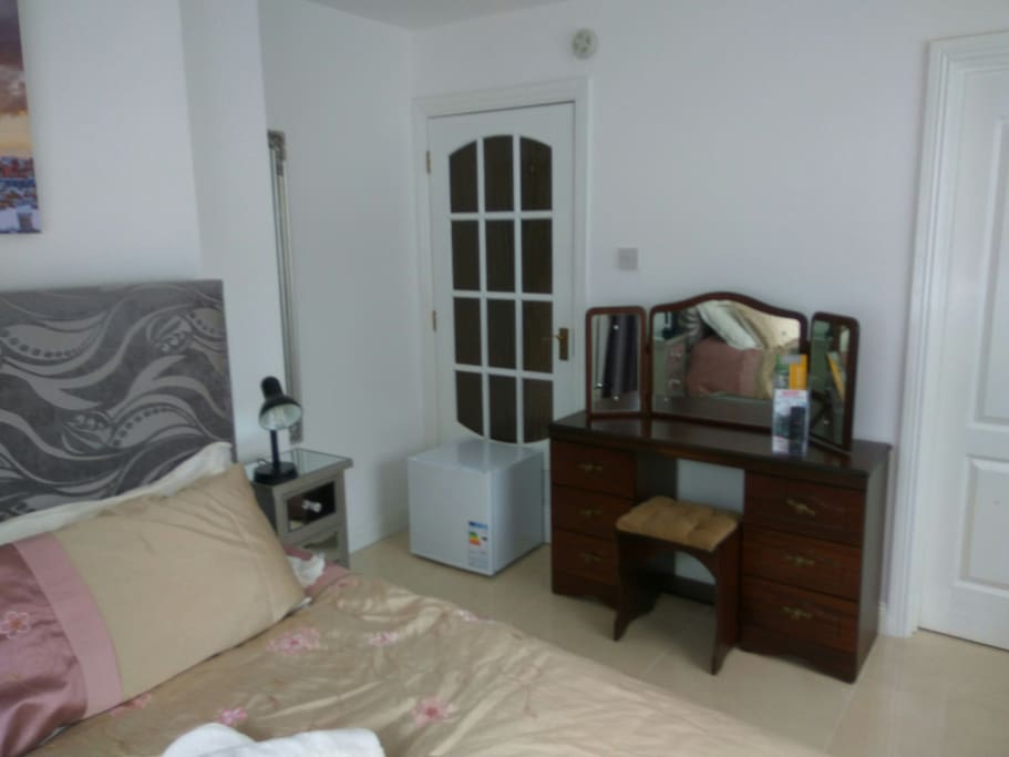 Mini-fridge located in front of permanently closed door.