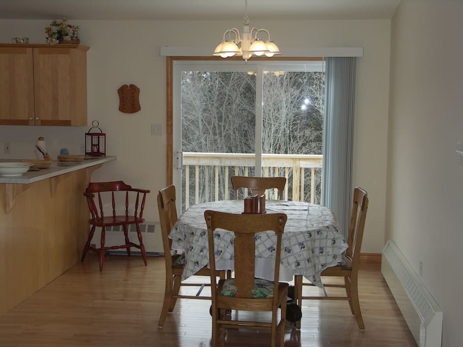The dining area opens onto a long deck with a patio table, 6 chairs and a grill.