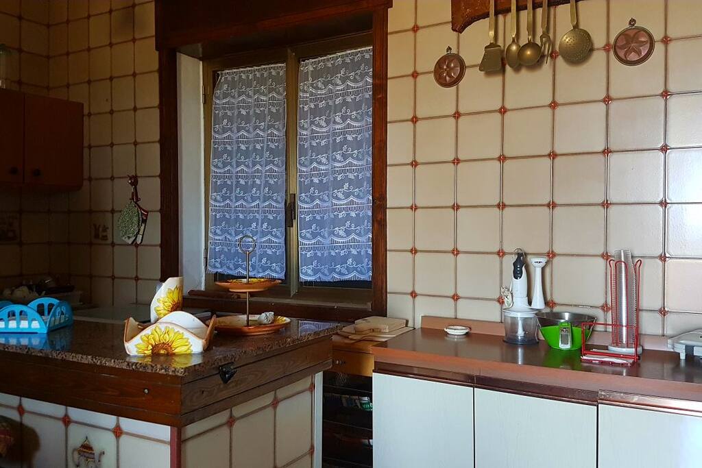 Ampia cucina ammobiliata con angolo cottura, frigorifero e congelatore