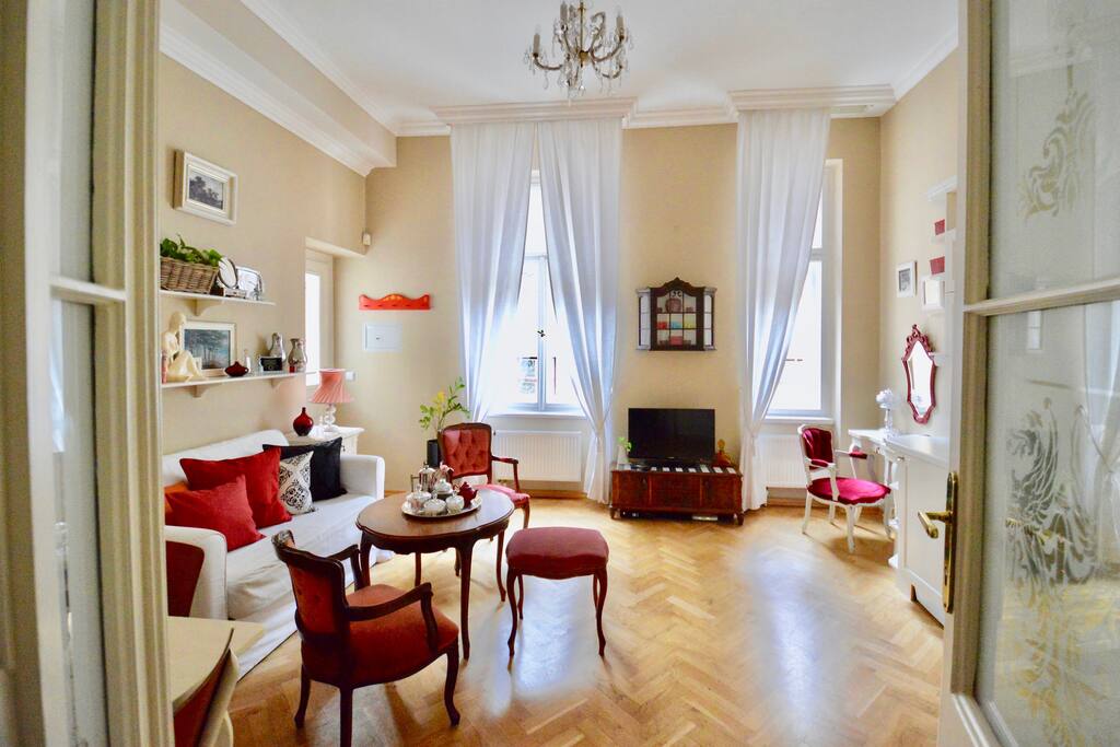 Spacious sunny living room with two windows facing quiet courtyard.