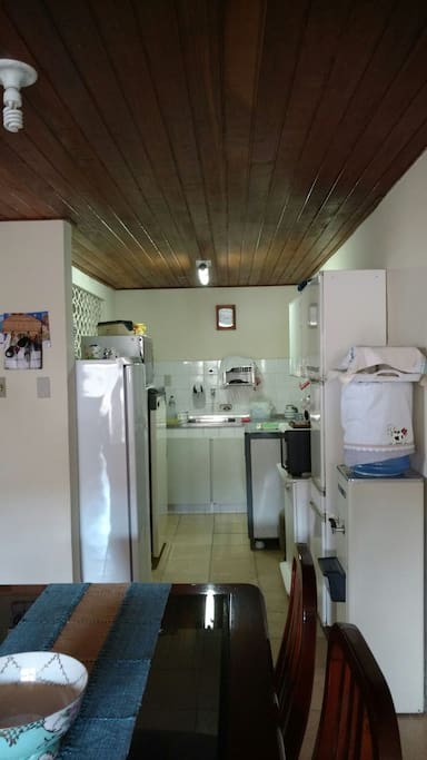 Cozinha com freezer, geladeira, fogão seis bocas, gelágua, forno elétrico e microondas.