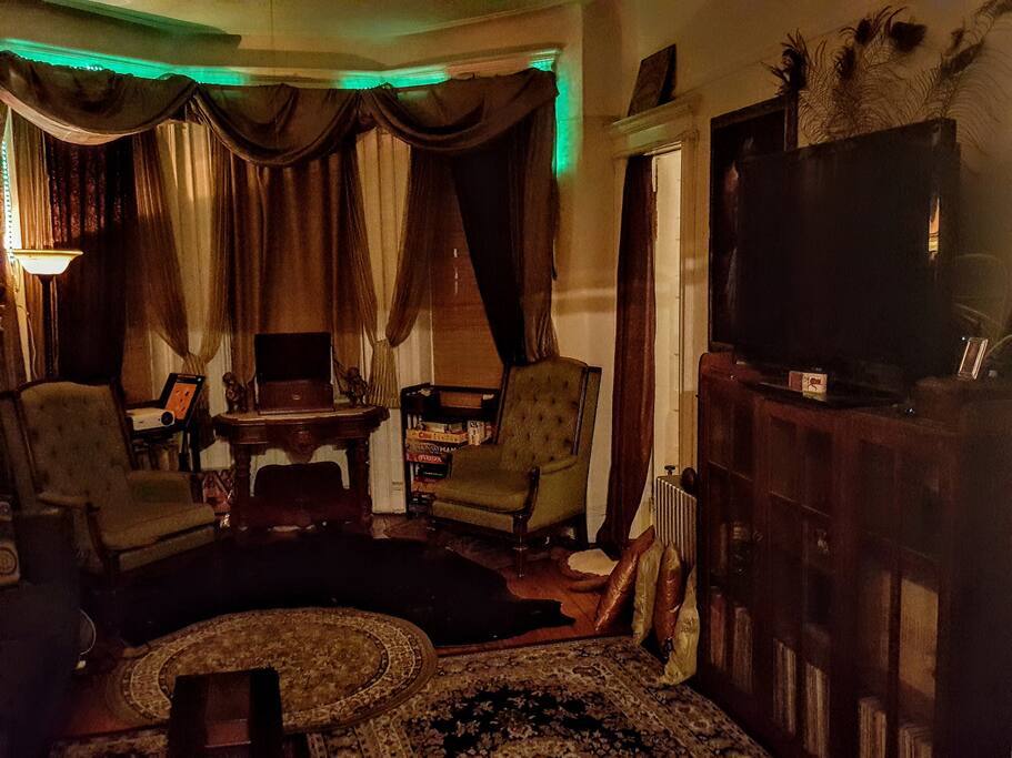 Living room with peak of bedroom door