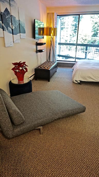 To keep the space tidy, storage ottomans hold the linens for the beds when folded away