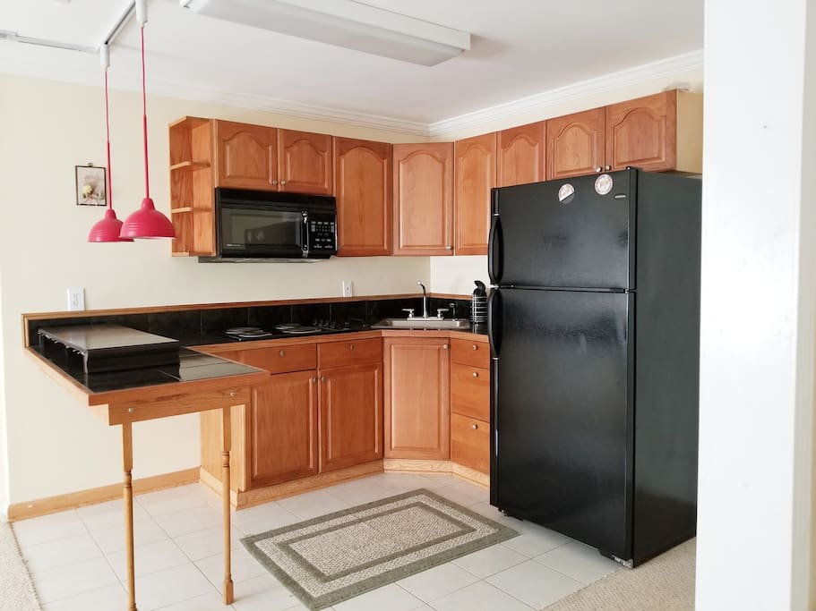 Kitchen with microwave, stove and refrigerator