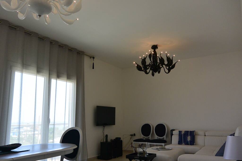 living room with sea view balcony, large sofa, dining table sitting 6 people