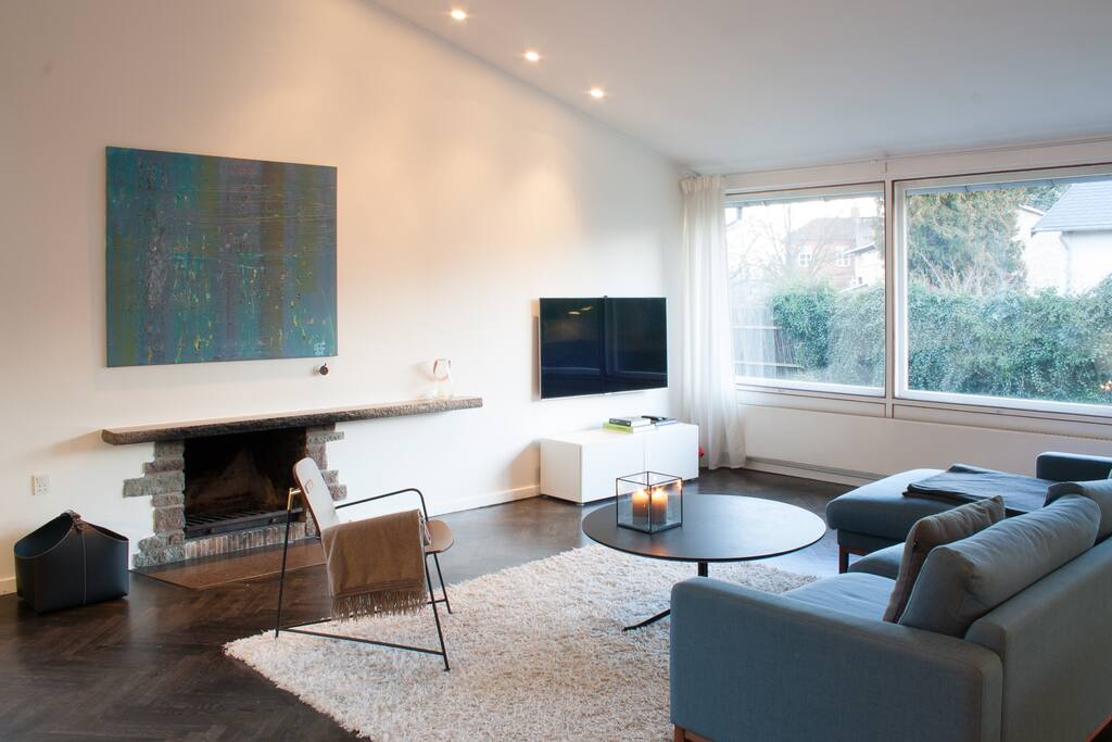 The living room includes fire place, large Smart TV, Bang & Olufsen sound system, Playstation 4, and video-on-demand services.