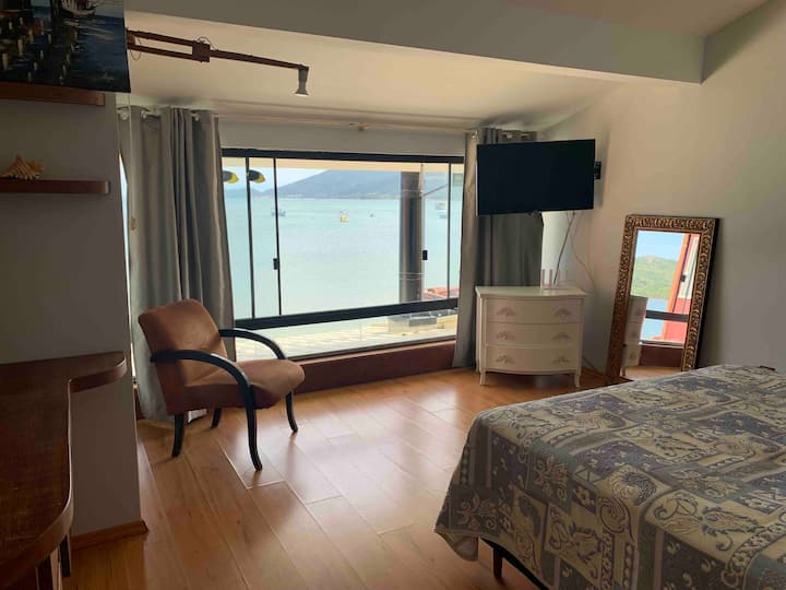 חדר עם מיטת קווין סייז ונוף לים.