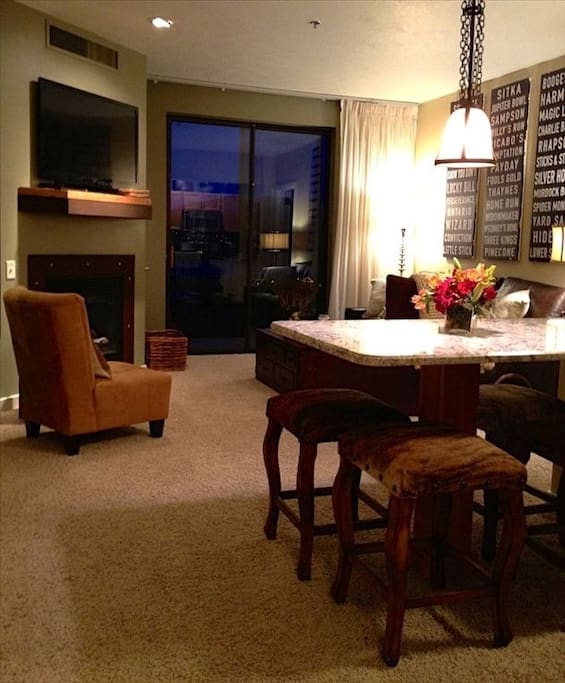 Open kitchen/den with fireplace & flatscreen leading to balcony overlooking Jordenelle