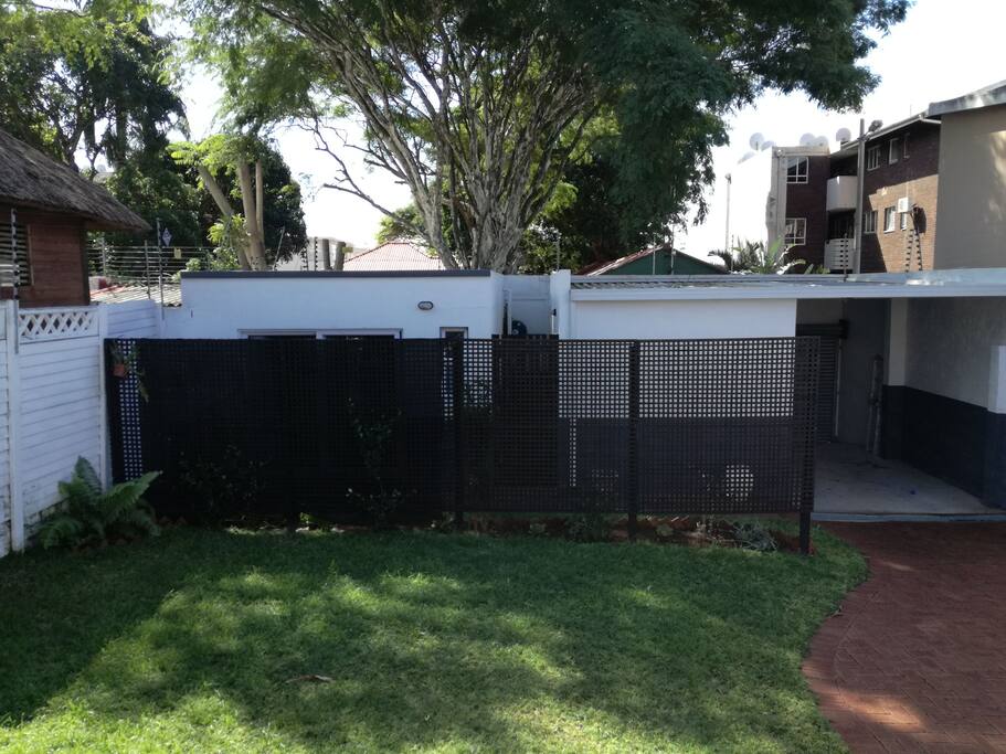 View of the flat from the main house. Undercover parking, shown to the right of the flat, is available.