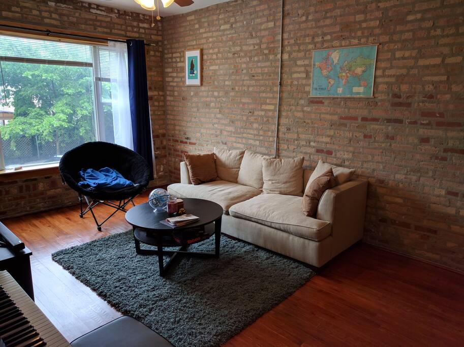 Living room has a couch and exposed brick