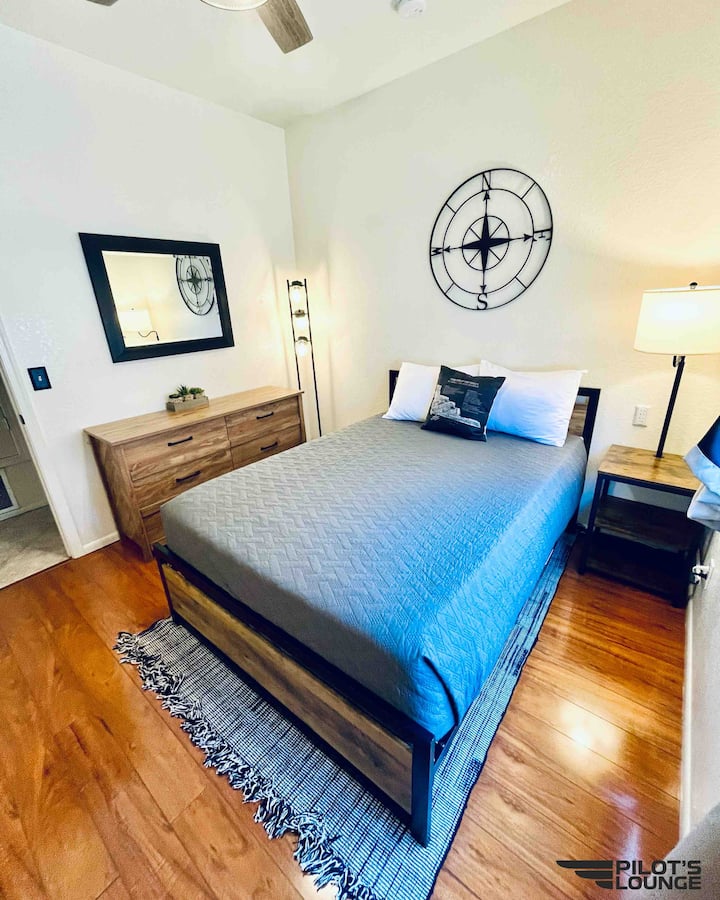 Navigator Bedroom: Full bed, dresser, vanity mirror, nightstand with USB charging port, full-length mirror, closet with hangers and luggage racks, spare aviation blanket, modern ceiling fan
