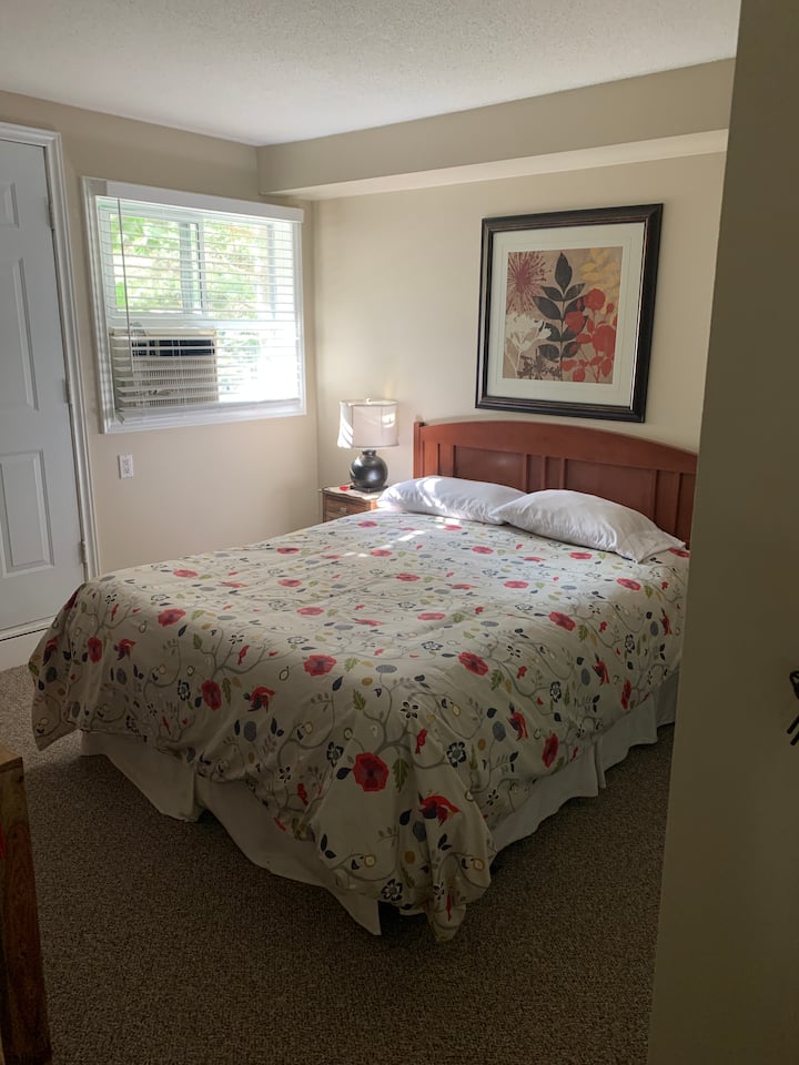 Cama tamaño queen en el dormitorio principal con baño privado y puerta exterior.
