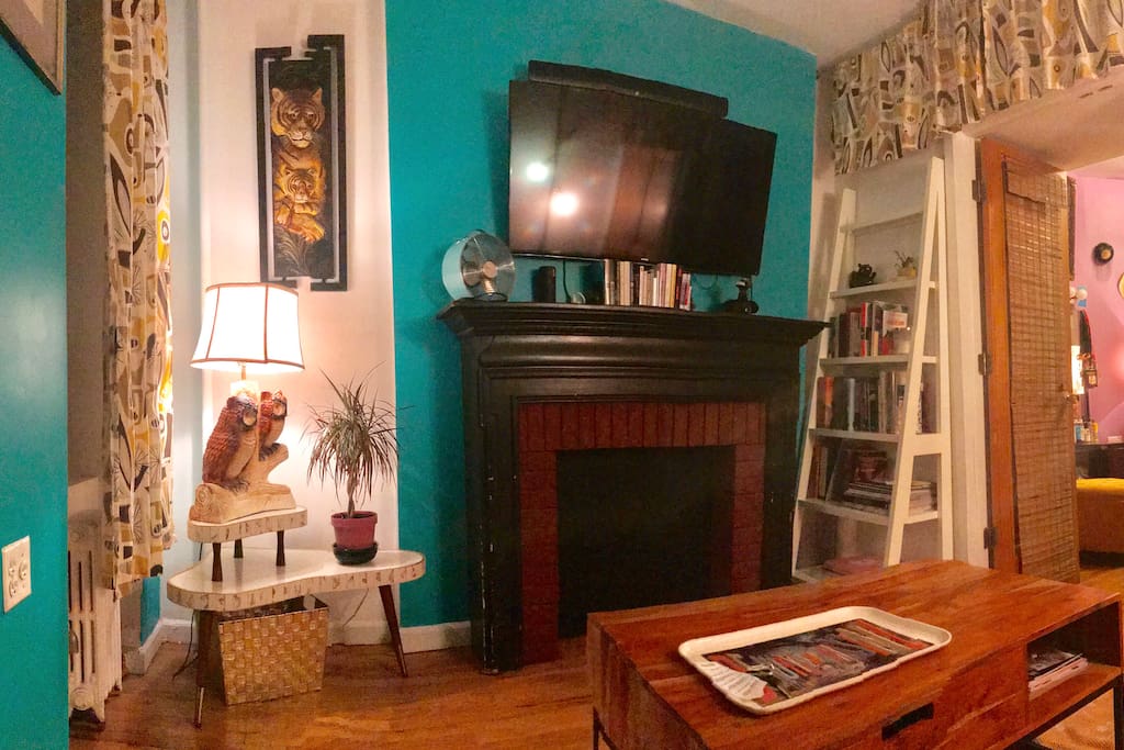 Living room with Smart TV/Netflix/Hulu etc, decorative fireplace, and charming mid century style furnishings.