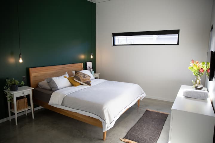 Camera da letto 1 con WIR (dietro la parete verde), bagno interno e finestre che si affacciano sulla zona della piscina. 