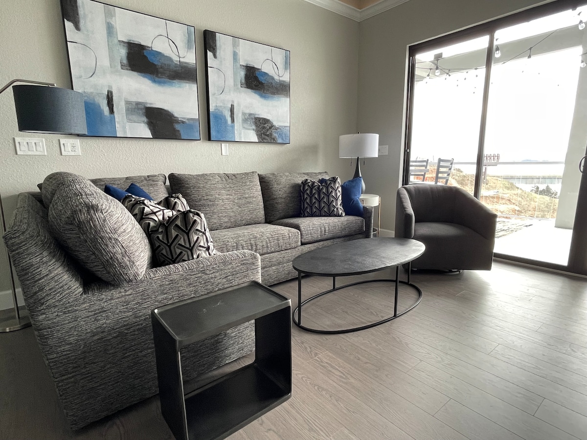 Mwonekano mzuri wa ziwa na dari ndefu kutoka kwenye sebule ya ghorofa ya juu. 