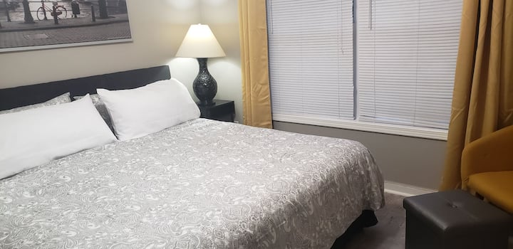 Seconda camera da letto matrimoniale grande con finestra di grandi dimensioni, posti a sedere e smart tv.