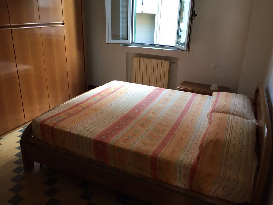 Camera matrimoniale. Sono presenti: letto a due piazze, ampio armadio, comodino, cassettiera e specchio.