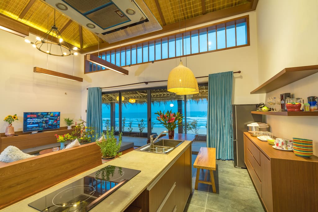 the opened living room and kitchen facing up to the beach