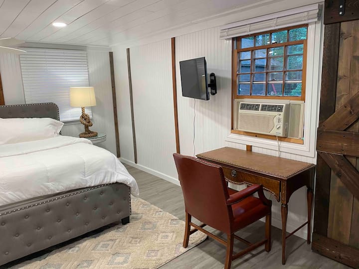 Dormitorio tamaño king con TV y escritorio.