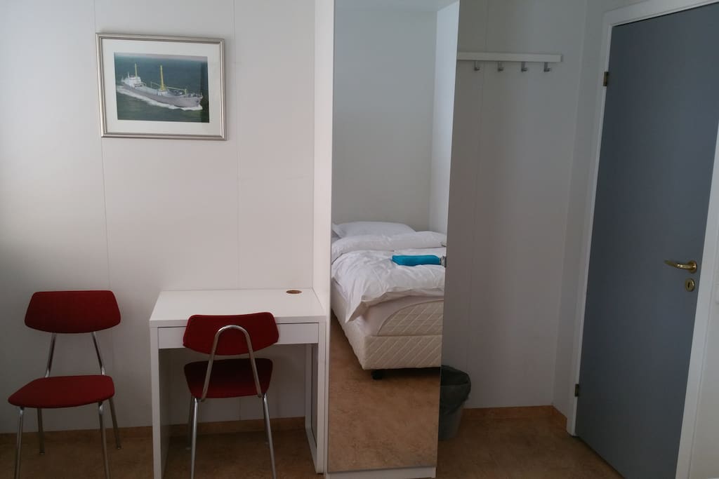 other side of the bedroom showing cabinet and desk
