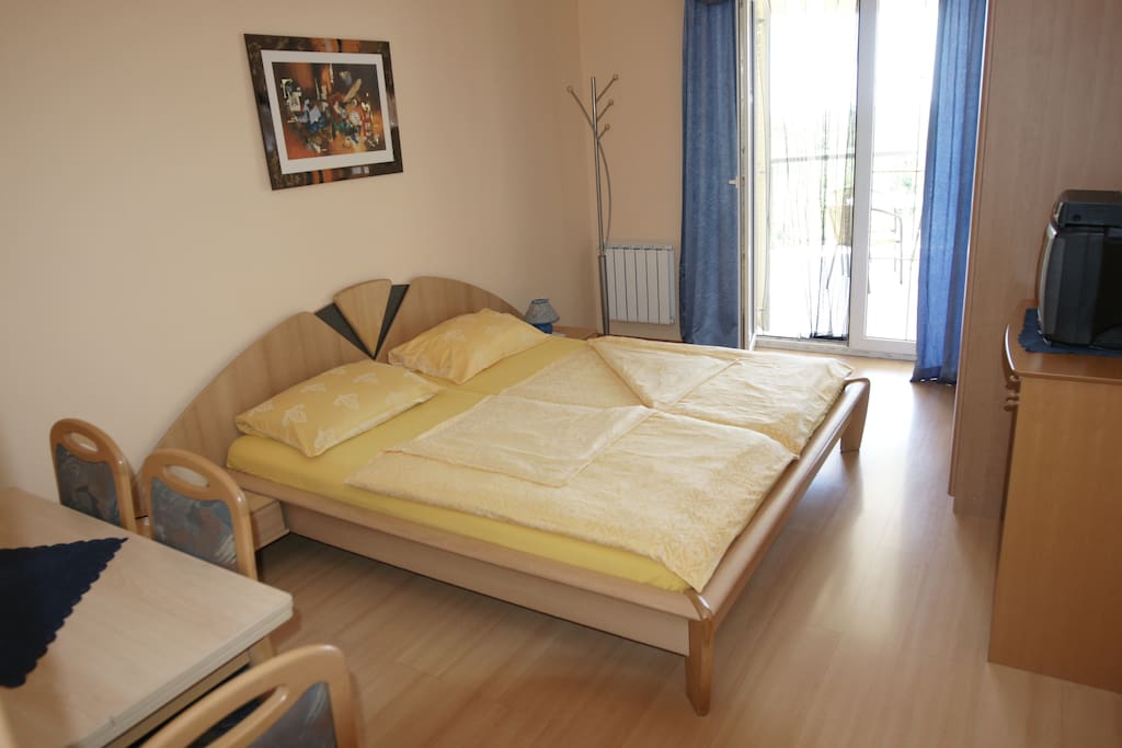 Schlafzimmer mit Zugang zum Balkon mit Blick auf Garten, Pool und Meer