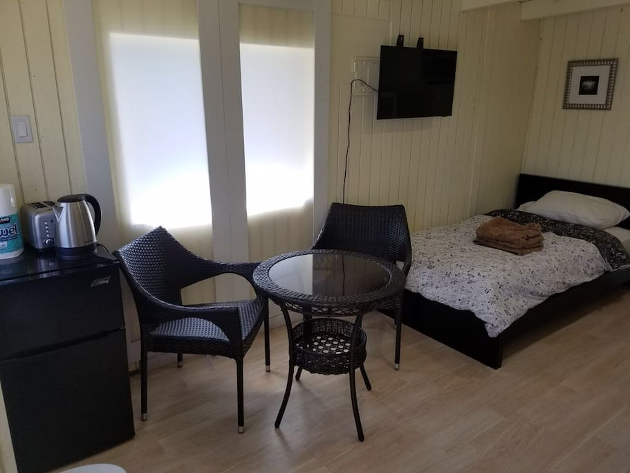 Mini kitchenette includes seating area with mini fridge, toaster, kettle.