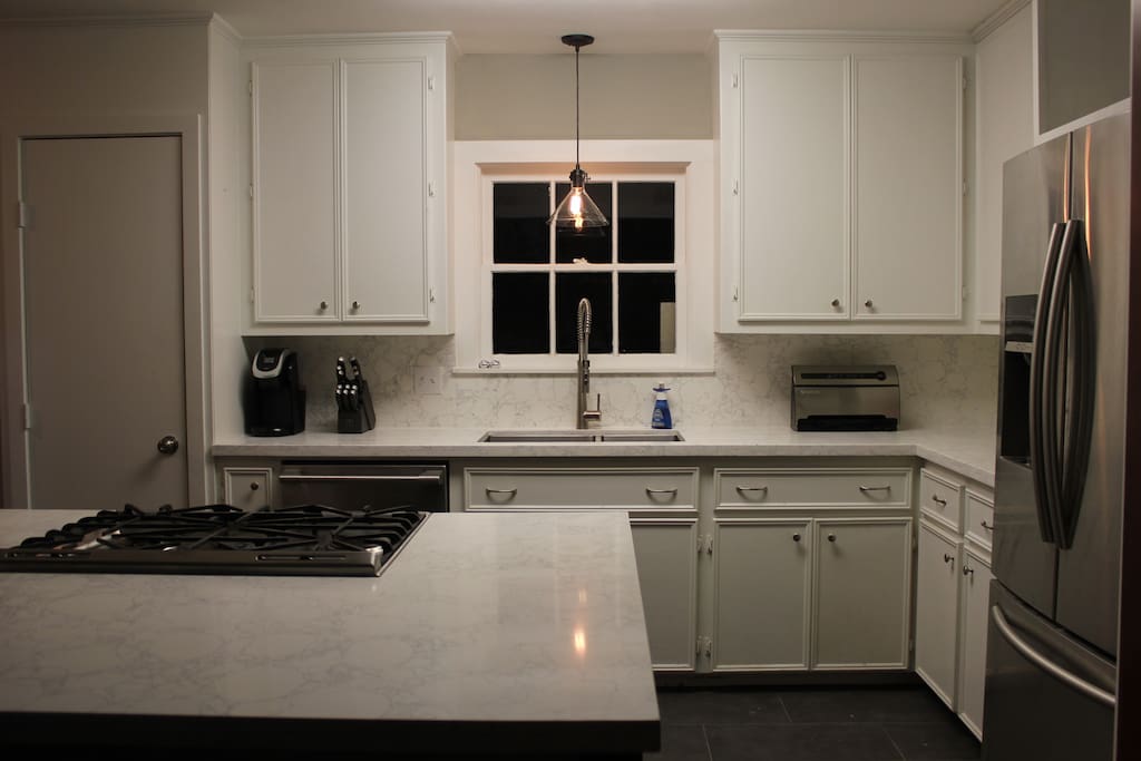 Chef's Kitchen-Recently remodeled luxury kitchen with beautiful quartz cabinets, large island open to dining room, and high end appliances. Over looks the back deck.