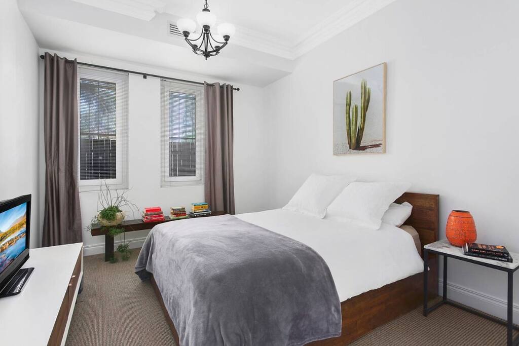 Large master bedroom with Queen bed and built ins, plus TV and speakers.