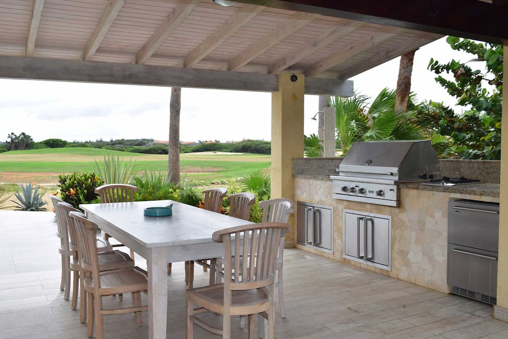 Terrace with 8-seat dining table and outdoor kitchen with large BBQ-grill
