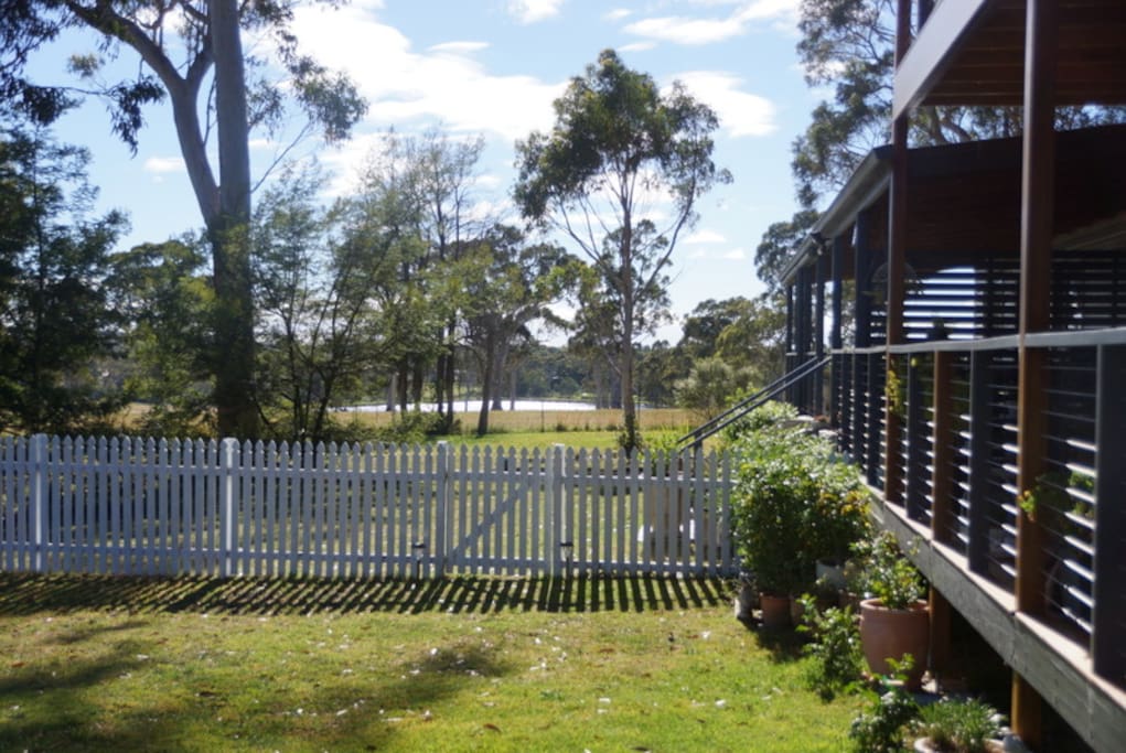 Looking East: entry gate to main cottage and view towards large neighbouring dam beyond
