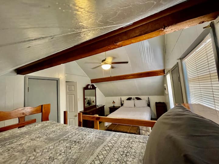 楼上的卧室配有一张标准双人床，还有一个梳妆台和储物床头柜。从双层床上可以看到美丽的景色。