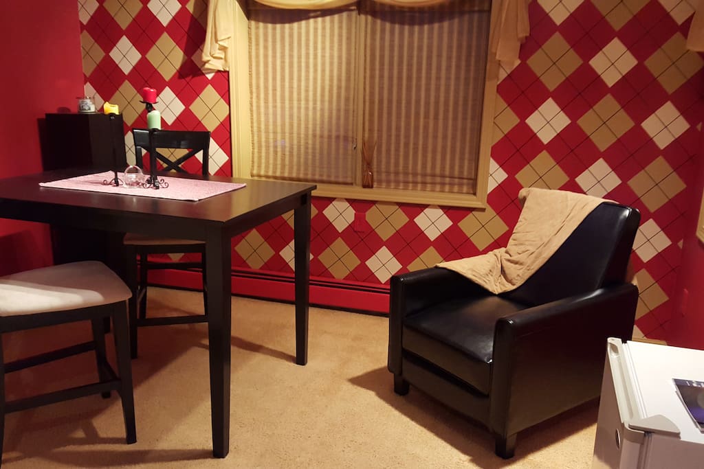 The Red Room sitting area with refrigerator, recliner, and cafe table.