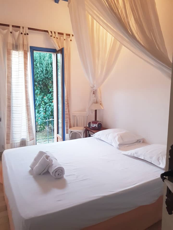 საძინებელი კარადათი და ფანჯრით, რომელიც იხსნება კერძო ბაღზე