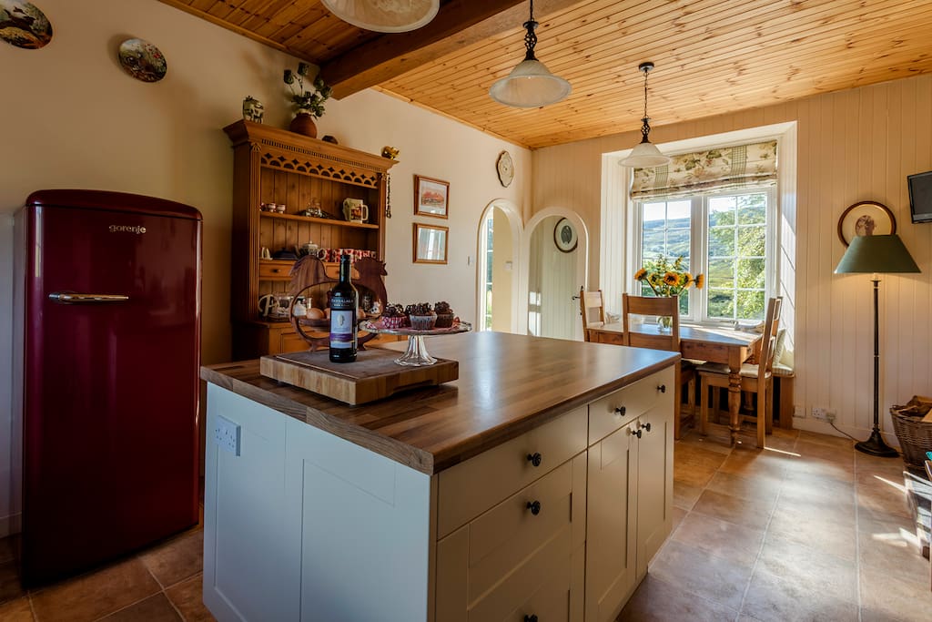 Island unit, wood burner, window seat and kitchen table.