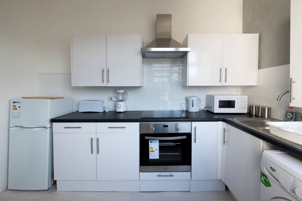 Kitchen with Fridge/Freezer, Washing Machine, Oven, Hob and utensils, plates, cups