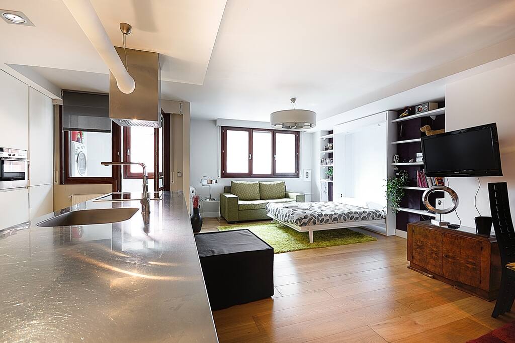 salón y zona de estar. cuenta con sofa y una cama que va en la pared que se baja cuando hace falta.